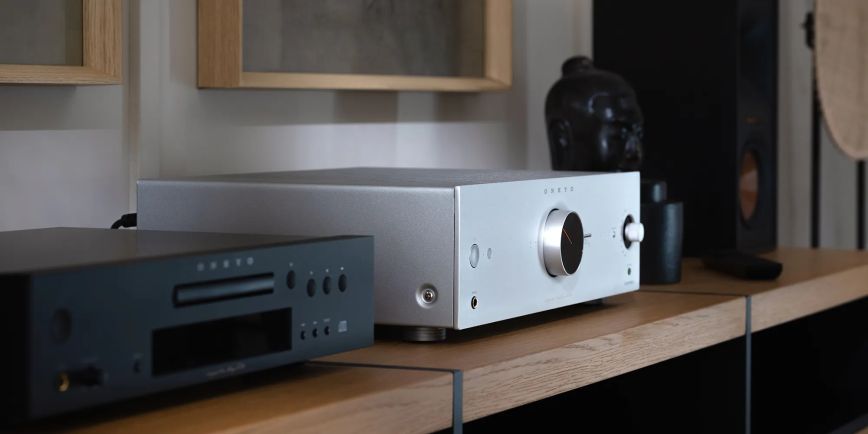 onkyo_icon_a_50_silver_angled_beside_klipsch_bookshelf_speaker_and_light_art_on_wall_2000x1000.jpg