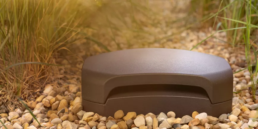 klipsch_courtyard_subwoofer_outside_buried_in_patio_gravel_at_golden_hour_3_2000x1000.webp