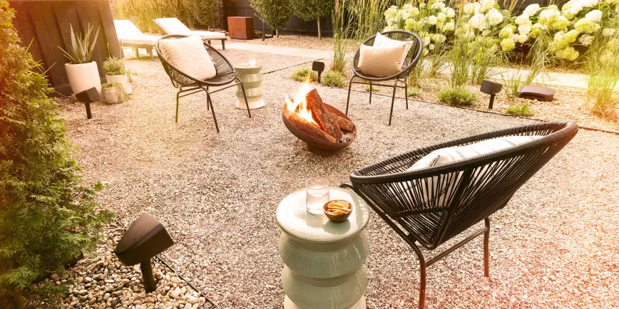 klipsch_courtyard_speakers_outside_on_cozy_patio_with_fire_pit_at_golden_hour_2000x1000.webp